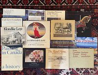Large collection of hardcover Canadian books laid out on a patterned carpet, titles visible include art history and photography themes.
