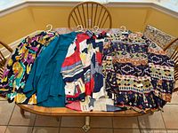 Four men's silk shirts laid out on a table showing various colorful and patterned designs.