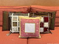 Photo of six decorative throw pillows showing various embroidered, patchwork, and striped textile covers with tassels on a couch.