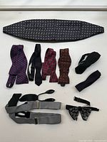 Overview of all items: cummerbund, multiple untied bow ties, suspenders, and lace bow tie