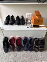 Photo of 6 pairs of men’s shoes including dress shoes, water shoes, boat shoes, sandals, along with shoe care box, brush, and laces.