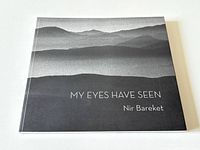 Front cover of the art book 'My Eyes Have Seen' showing layered mountain or hill landscape in grayscale with title and author name text.