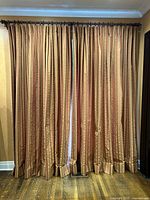 Front view of two striped drape panels hanging fully closed on the rod.