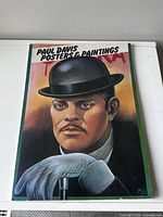 Front cover of the Paul Davis Posters and Paintings softcover art book showing a painted portrait of a man with a bowler hat and white glove.