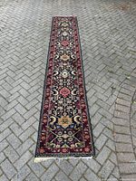 Full-length view of runner laid on driveway pavement showing overall design, colors and condition of fringes