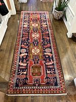 Top-down view of entire carpet runner on hardwood floor showing geometric and bird motifs