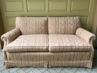 Front view of the pink loveseat sofa showing upholstery and rolled armrests