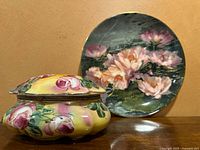 Floral ceramic trinket box with pink roses on yellow background and floral signed plate in background