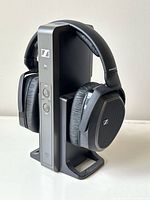 Pair of Sennheiser HDR 175 wireless headphones resting on their black charging stand with power and control buttons visible.