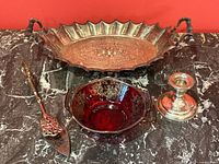 Full view of the lot including silver plate tray with handles, cranberry glass bowl with silver appliqué, silver tongs, and sterling silver Birks candlestick