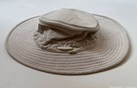 Front view of beige wide-brim sun hat by Tilley Endurables showing crown and brim with stitched details.