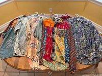 Nine vintage 80's men's Hawaiian shirts in various colors and styles laid out on a table.