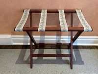 Front view of wooden folding stand showing floral fabric straps and X-leg design.