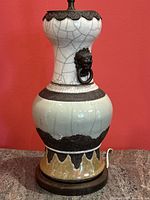 Full front view of entire lamp on table against red wall