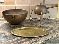 Photo showing the full set of three items on granite surface: copper mixing bowl, fondue pot with stand, and brass tray.