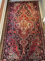 Full view of runner laid on floor showing entire geometric pattern and fringed ends