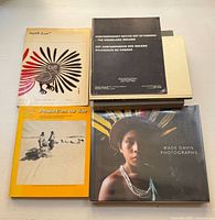 Top view of five vintage Indigenous art and culture related books including Wade Davis Photographs, Contemporary Native Art of Canada, and People From Our Side.