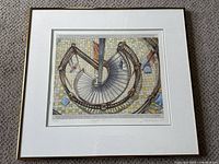 Framed art print showing a spiral staircase viewed from above with detailed tile floor and small figures on staircase.
