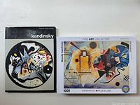 Photo showing Kandinsky hardcover book and Eurographics puzzle box side by side on a flat surface