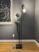 Full view of lamp showing four chrome spotlight heads on black base