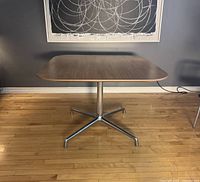 Front view of the square dining table showing wood grain laminate top and polished aluminum base