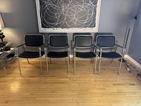 Front view of four chairs in a row against wall