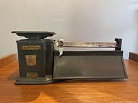 Front view of vintage Triner Air Mail Scale showing scale platform and sliding measurement arm with measurement gradations.