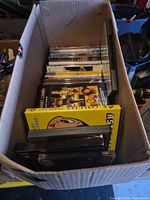 Box filled with DVD cases with Astro Boy and Friday Night Lights visible