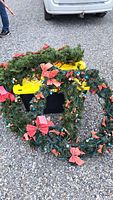 Coiled artificial wreaths showing foliage, lights, bows and ornaments
