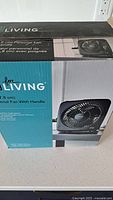 Front of sealed box showing For Living 7-inch personal fan image and specifications