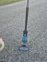 Full view of Bissell Adapt Ion stick vacuum standing upright on gravel
