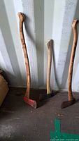 Three axes standing against wall showing overall size and condition