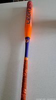 Full view of Worth Legit softball bat showing orange barrel, purple handle and brown grip