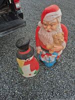 Santa and Snowman blow molds standing on gravel