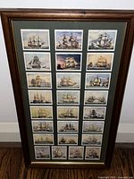 Close-up photo showing the detailed illustrations of 25 cigarette trade cards featuring navy boats in a 5x5 arrangement with green mat and wooden frame.