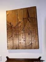 Front view of the signed Goreth hand carved wood art showing detailed village scene carved on multiple wood planks.
