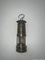 Frontal view of brass yacht lamp hanging against white background