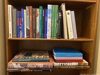 Wide shot of two shelves of art books, vertical and horizontal stacks visible