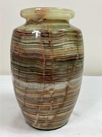Front view of polished banded onyx vase showing multicolour horizontal striations and overall shape