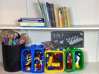 Shelf with Lego and Duplo cases, Barbie bucket, books and boxed board game
