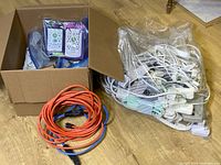 Box with packaged adapters/timers, bag of white cords, red and blue extension cords
