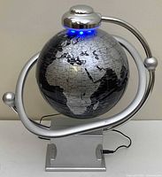 Front view of electromagnetic globe on stand showing continents and LED lights