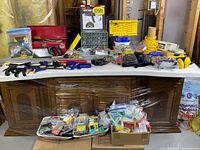 Overall lot on table: heat gun box, organizer drawers, toolbox, clamps, PPE, fasteners