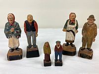 Six wooden folk art figurines displayed front view
