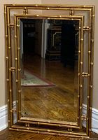 Front view showing gold faux bamboo frame around clear mirror