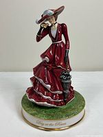 Front view of Royal Doulton “Day at the Races” figurine showing attire, parasol, and base inscription