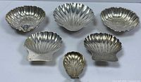 Front view of six sterling shell dishes