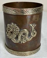 Front view showing silver dragon relief and copper body