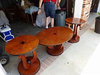 Three Biedermeier-style tables set outside garage