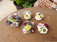 All five multicolor porcelain floral figurines displayed on tabletop